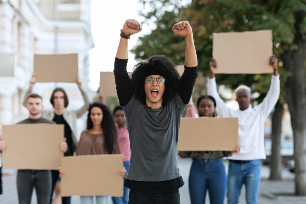 Young diverse group protesting with blank cardboard signs and raised fists