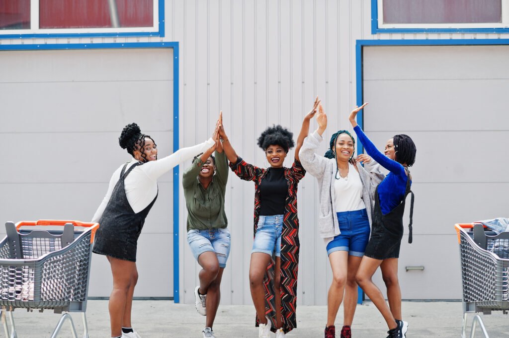 Five Black women celebrating joyfully with a high-five, symbolizing strength, pride, and unity